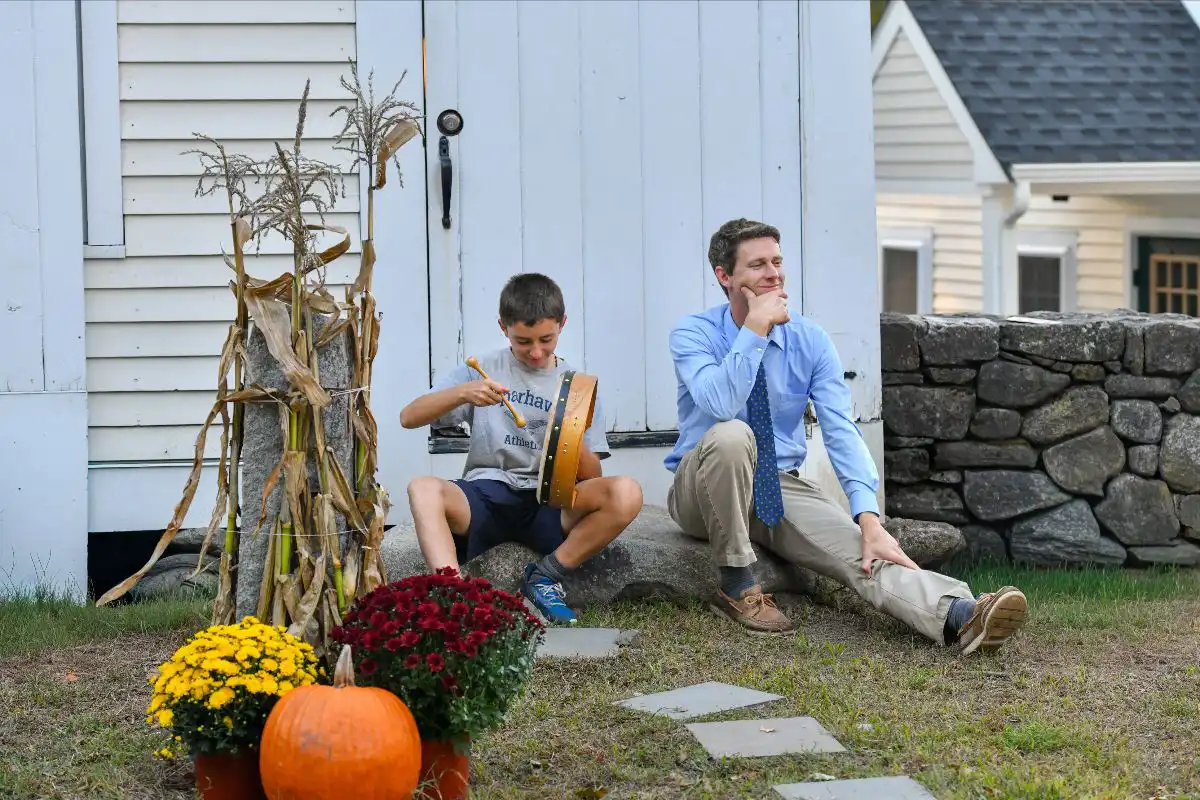Teacher and student outside by fall decorations