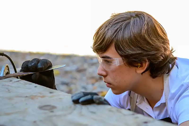 High School Male learning a trade