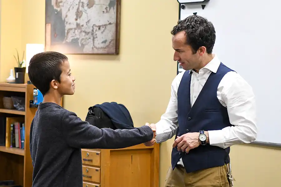 Sparhawk teacher mentoring student by fireplace