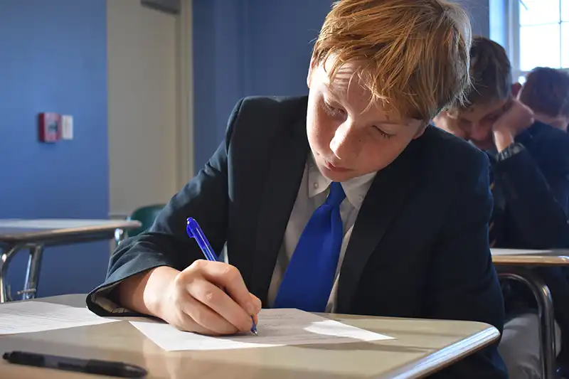 Middle School male student writing