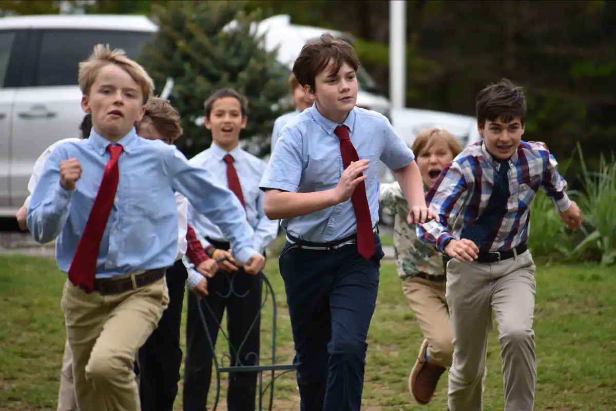 School boys in uniform running outside