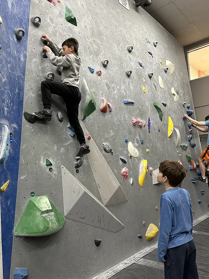 sparhawks-adventure-class-rock-climbing Male student sitting by fireplace reading Beowulf