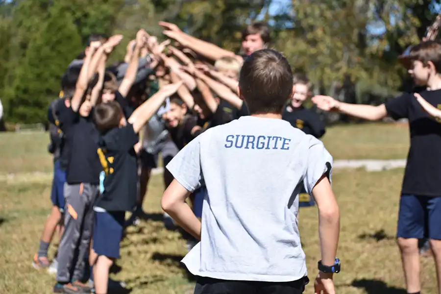 Boy running with tshirt that says Surgite