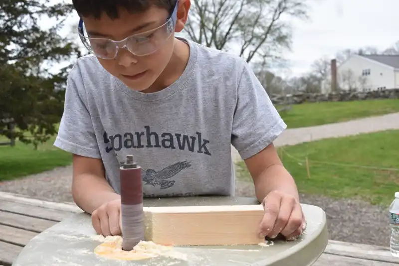 Boy sanding block of wood